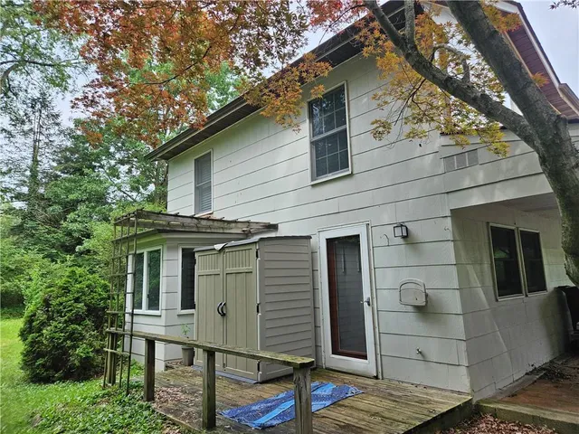 a front view of a house with a tree