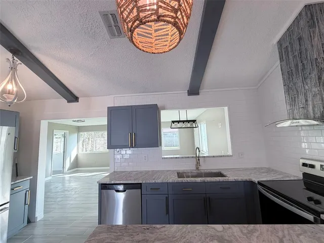 a kitchen with stainless steel appliances granite countertop a sink stove and cabinets