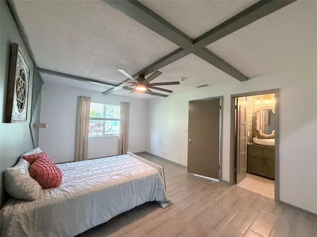a view of a hallway with wooden floor and cabinet