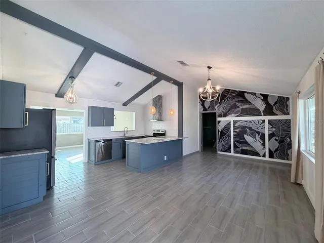 a view of a big room with wooden floor windows and a kitchen