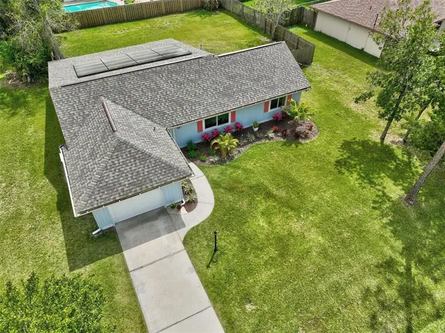 a aerial view of a house with a yard patio and green space