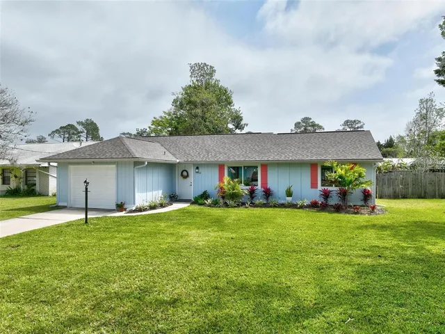a view of a house with a yard and sitting area