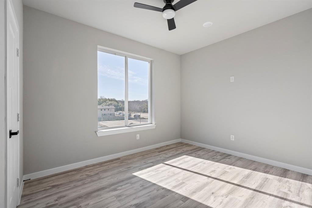 948 Corinth Street, Unit 5 Dallas, TX 75215 - Photo 14 of 28 Unfurnished room with a ceiling fan and light wood finished floors