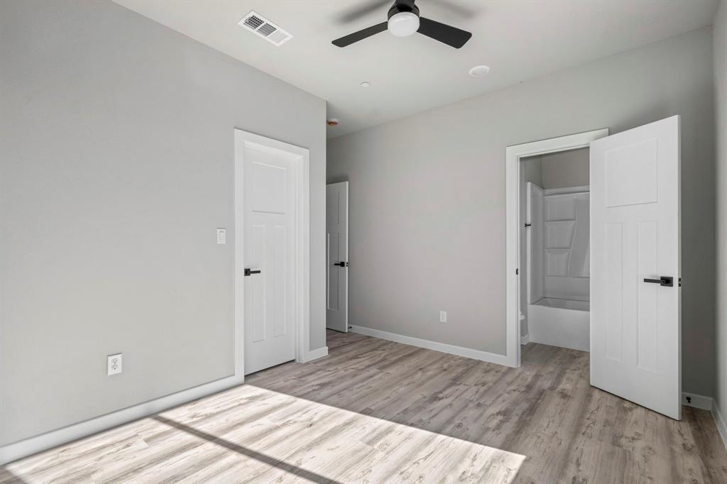 948 Corinth Street, Unit 5 Dallas, TX 75215 - Photo 15 of 28 Unfurnished bedroom with light wood finished floors, ceiling fan, and ensuite bathroom
