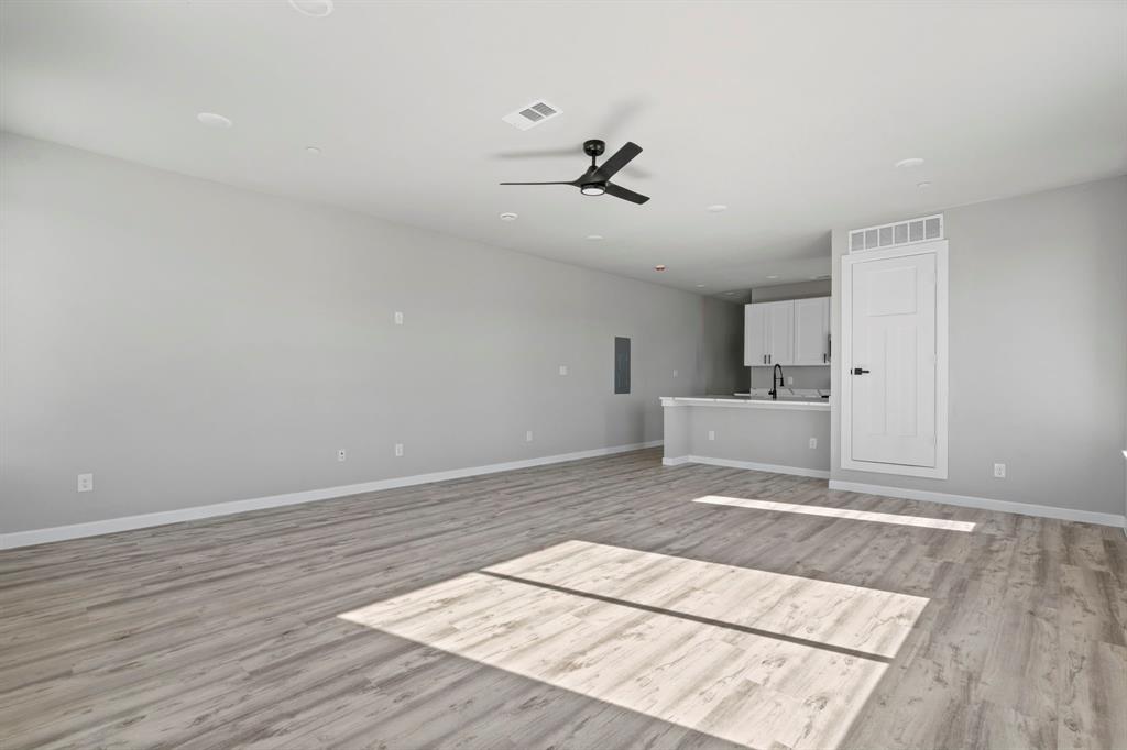948 Corinth Street, Unit 5 Dallas, TX 75215 - Photo 6 of 28 Unfurnished living room featuring a ceiling fan, light wood finished floors, and electric panel