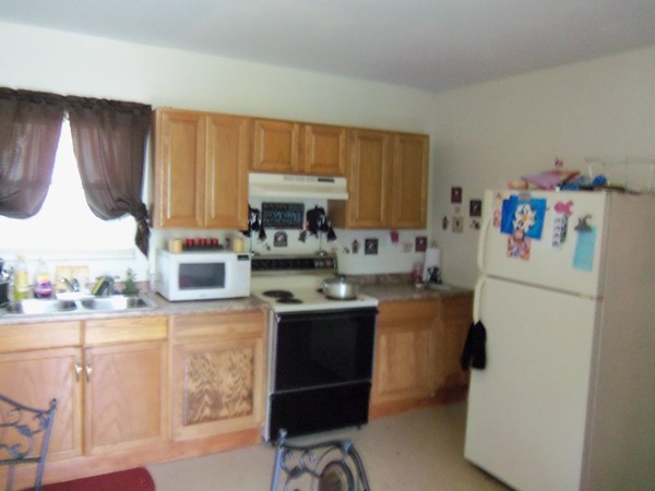 68 White Street Springfield, MA 01108 - Photo 3 of 5 a kitchen with a sink a stove and a refrigerator