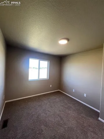 an empty room with closet and a window