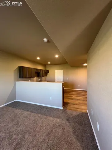 an empty room with yellow space and windows