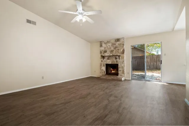 an empty room with windows and fireplace