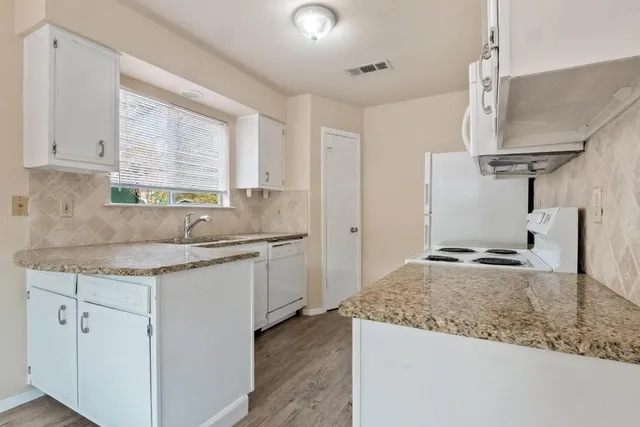 a kitchen with a sink stove and cabinets