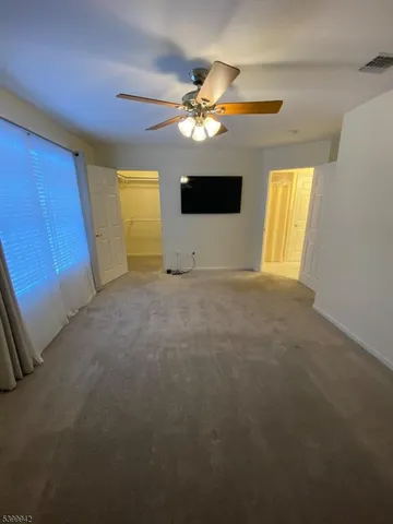 a view of a livingroom with a ceiling fan and window