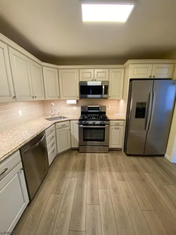 a kitchen with a sink a microwave and cabinets