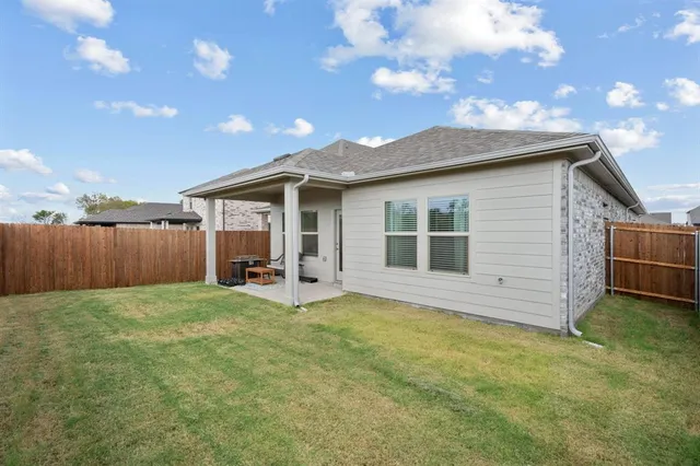 a view of a backyard with wooden fence and a bench