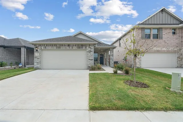 a front view of a house with a yard and a garage