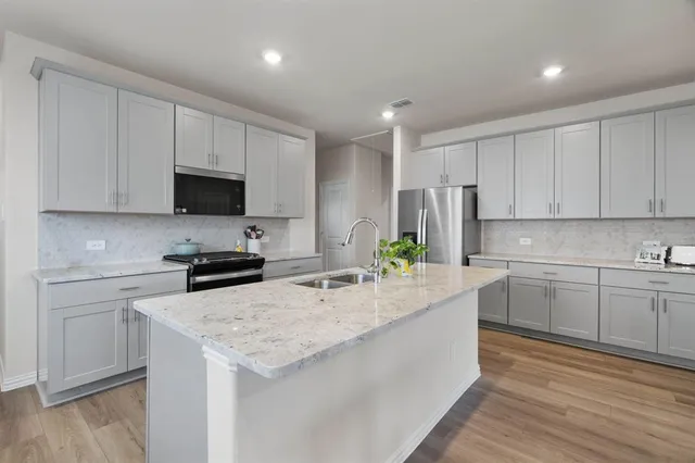 a kitchen with counter top space sink and center island
