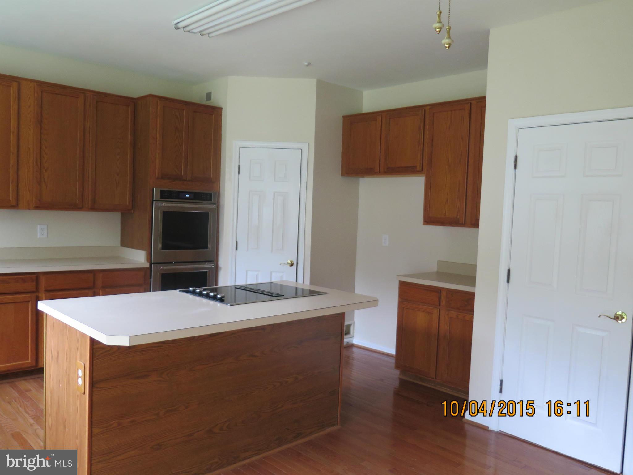 8506 Topaz Court Clinton, MD 20735 - Photo 11 of 30 a kitchen with stainless steel appliances granite countertop a refrigerator a stove and a sink with wooden floor