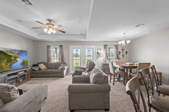 a living room with furniture a ceiling fan and a window