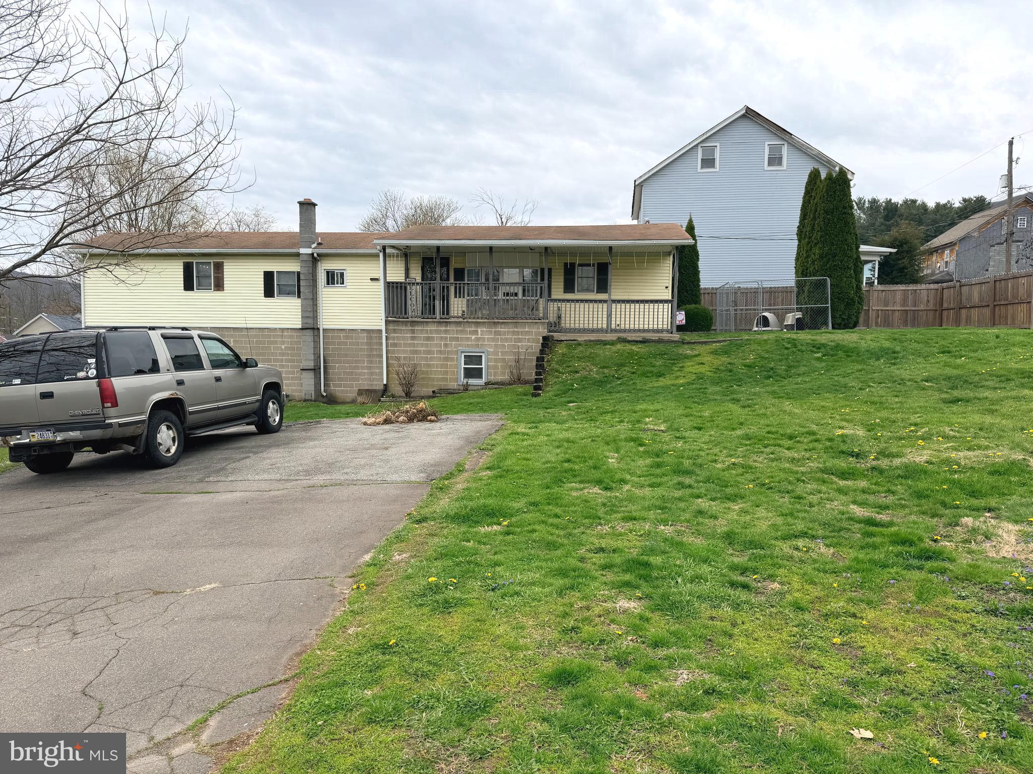 217 Oak Street Wiconisco, PA 17048 - Photo 2 of 31 a view of a white house in front of a yard with lawn chairs and a large tree