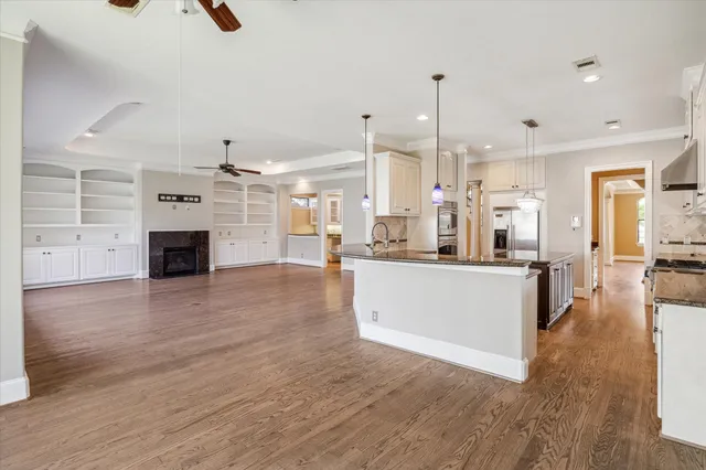 a view of a kitchen with kitchen island a sink stainless steel appliances and cabinets