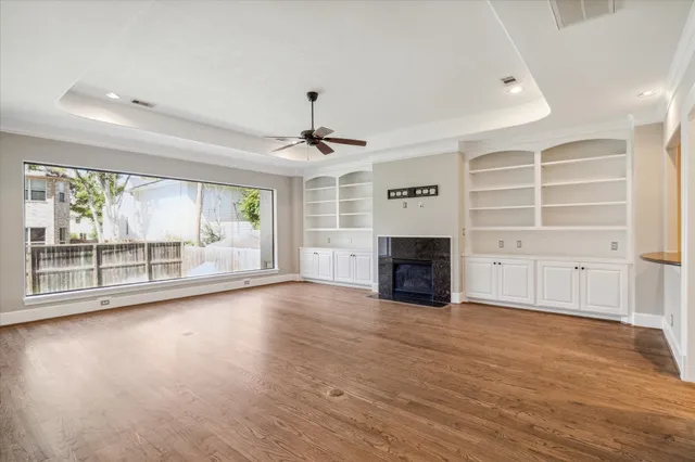 wooden floor fireplace and windows in an empty room