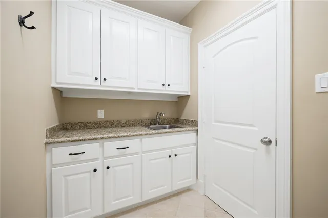 a room with white cabinets and a sink