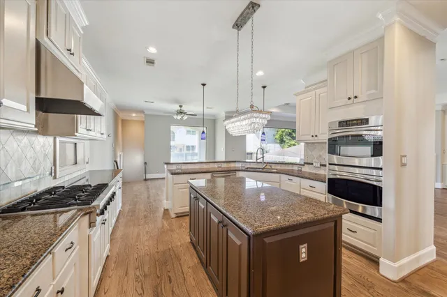 a kitchen with stainless steel appliances granite countertop a stove a sink dishwasher and a refrigerator