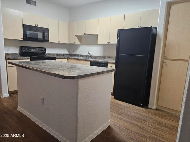 a kitchen with a refrigerator and a stove top oven