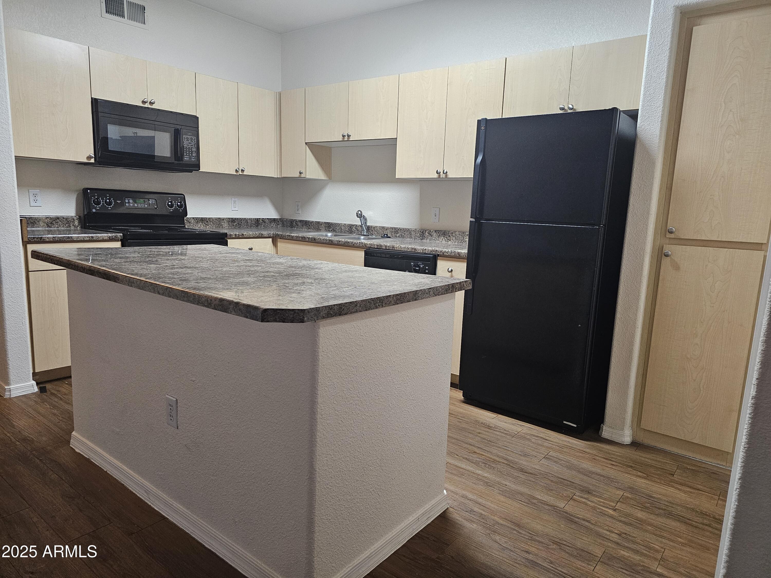 18416 North Cave Creek Road, Unit 1011 Phoenix, AZ 85032 - Photo 3 of 11 a kitchen with a refrigerator and a stove top oven