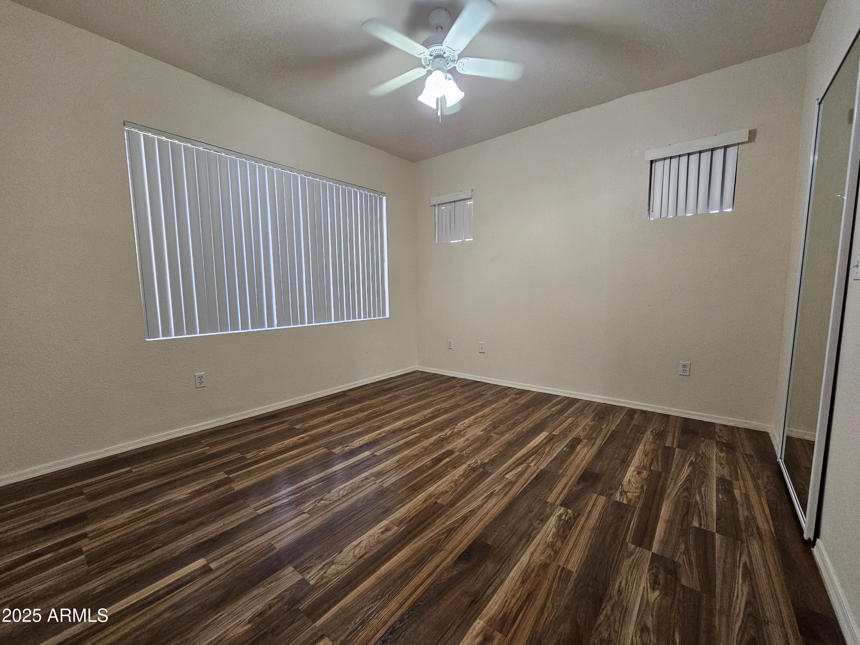 18416 North Cave Creek Road, Unit 1011 Phoenix, AZ 85032 - Photo 4 of 11 a view of an empty room with wooden floor and a window