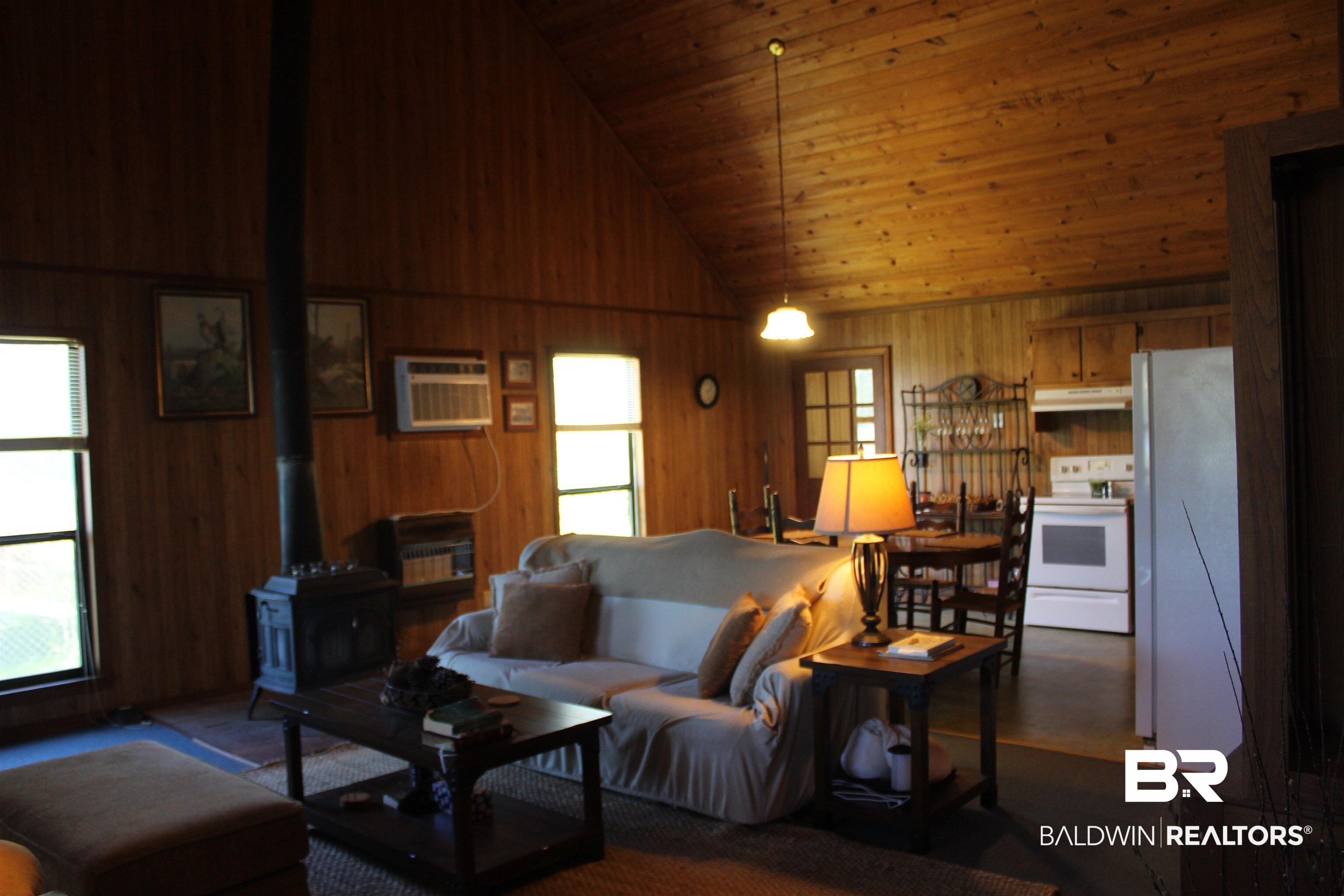 6447 Henderson Road Lowndesboro, AL 36752 - Photo 11 of 22 Living area with a wood stove, wood walls, and a vaulted wooden ceiling