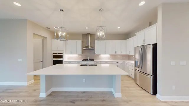 a kitchen with a refrigerator a sink and chairs