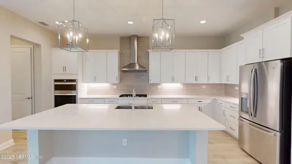 a kitchen with kitchen island white cabinets and stainless steel appliances