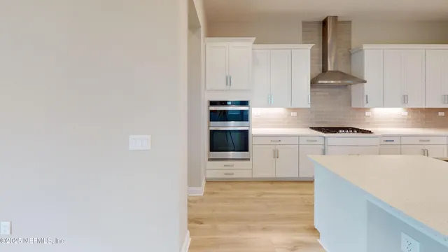 a kitchen with granite countertop white cabinets and stainless steel appliances