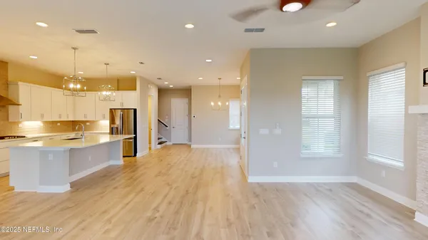 a large kitchen with stainless steel appliances kitchen island a large counter top and a wooden floors