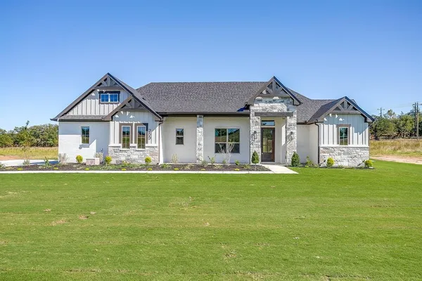 a front view of a house with a garden and yard