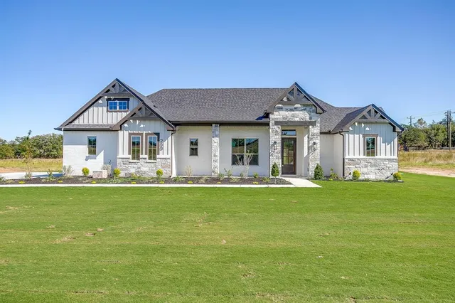 a front view of a house with a garden and yard