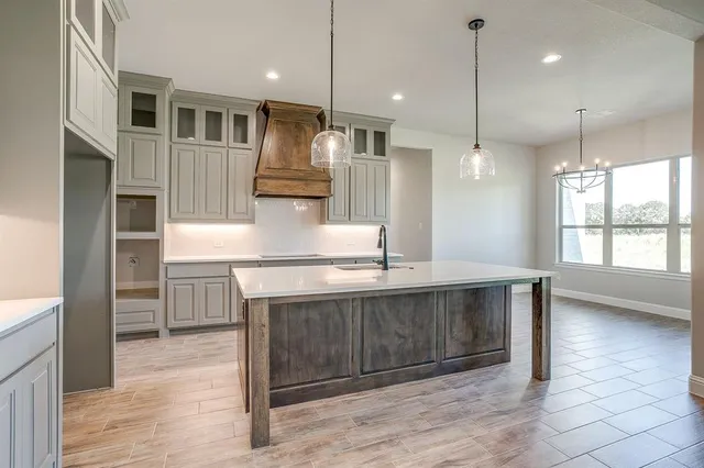 a large kitchen with kitchen island a large island in it