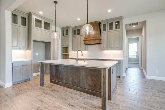 a kitchen with stainless steel appliances granite countertop a sink a stove and a wooden floors