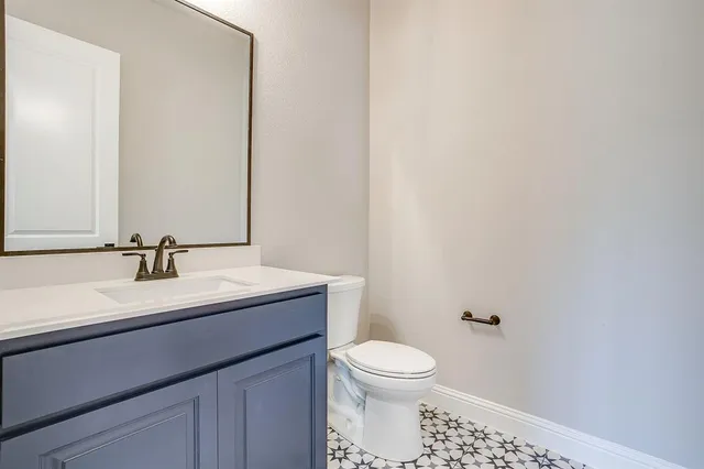 a bathroom with a toilet a sink and mirror