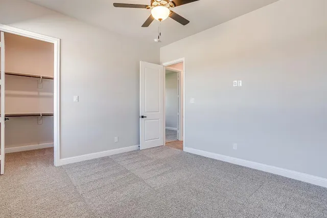 an empty room with a ceiling fan and a window