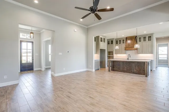 a view of an empty room with window and wooden floor