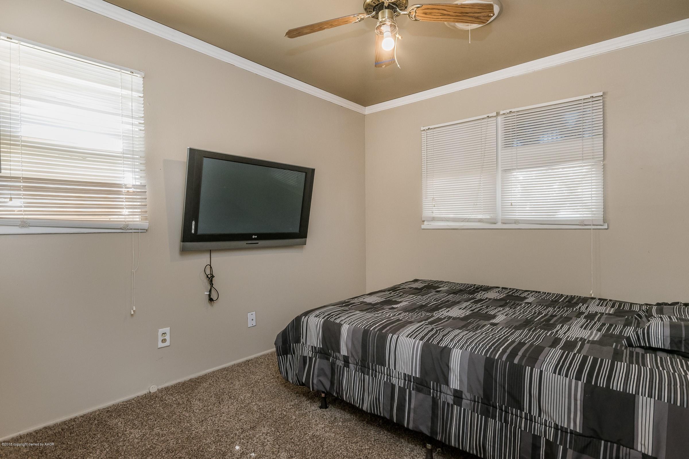 5137 South Bonham Street Amarillo, TX 79110 - Photo 13 of 18 a bedroom with a bed and a flat screen tv