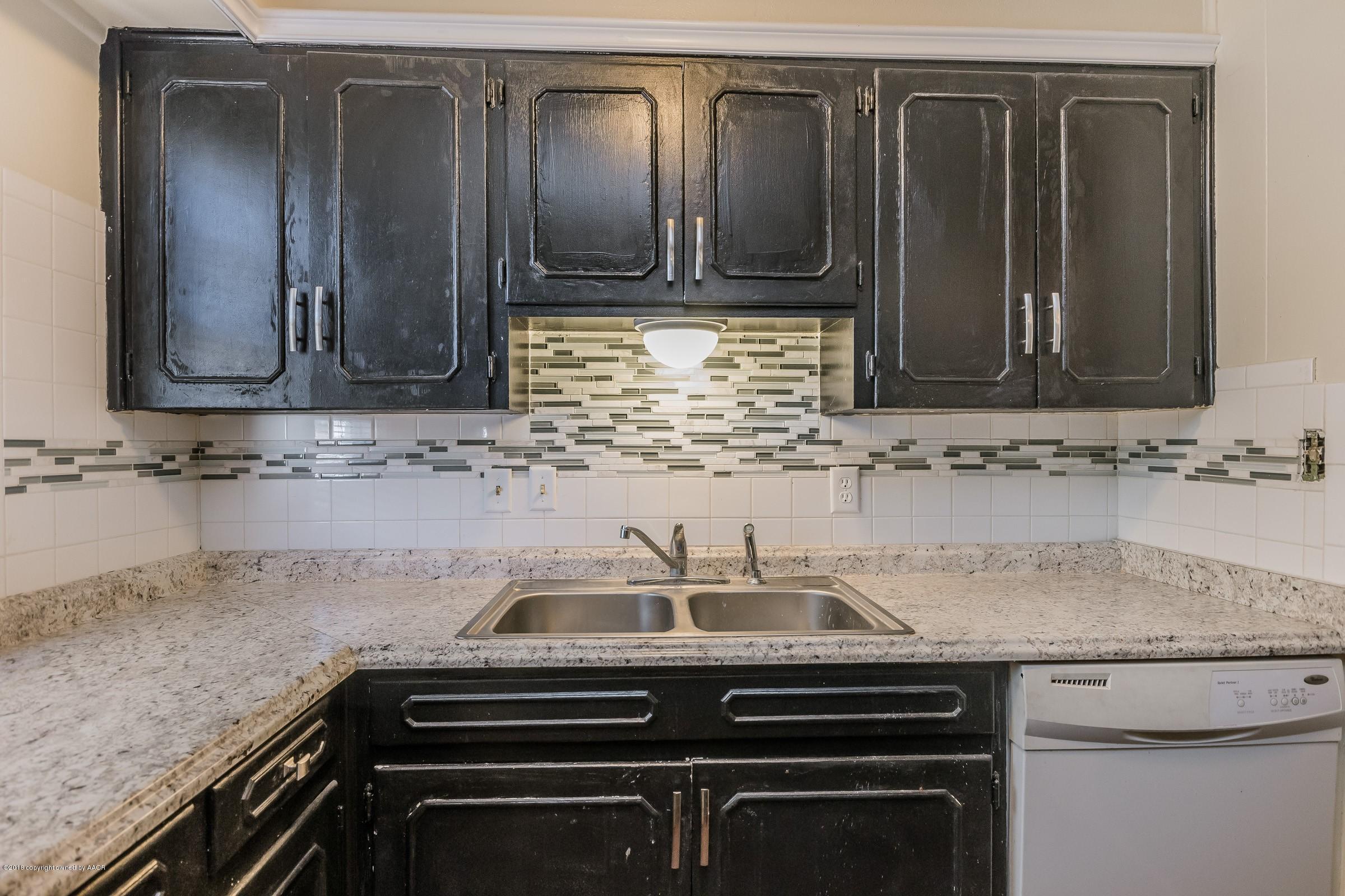 5137 South Bonham Street Amarillo, TX 79110 - Photo 10 of 18 a kitchen with granite countertop a sink stove and cabinets