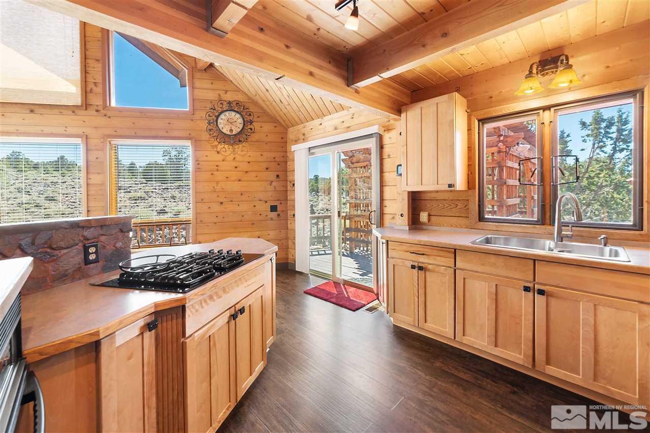3880 Stovepipe Road Reno, NV 89521 - Photo 4 of 40 a open kitchen with stainless steel appliances granite countertop a stove a sink dishwasher and a dining table with wooden floor