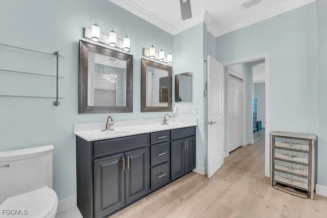 a spacious bathroom with a toilet a sink a vanity and mirror