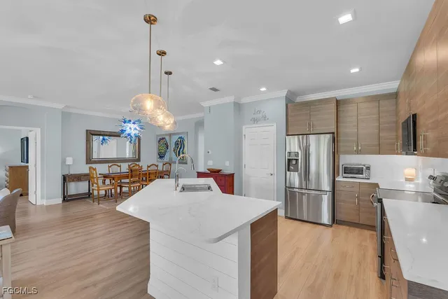 a kitchen with stainless steel appliances a dining table chairs stove and refrigerator