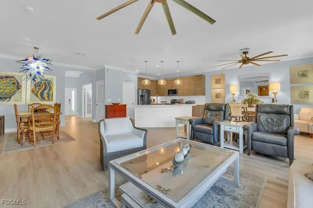 a living room with furniture a chandelier and a dining table