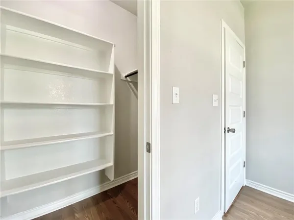 a view of walk in closet with empty racks