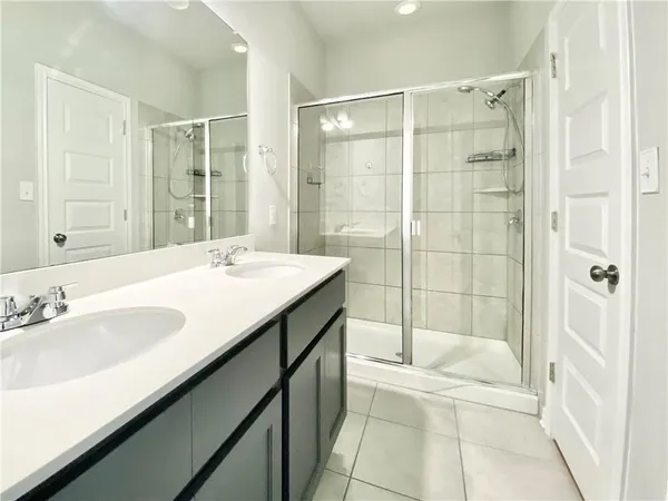 a spacious bathroom with a shower sink and mirror