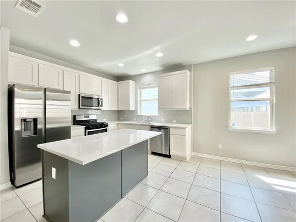 a kitchen with stainless steel appliances a refrigerator sink stove microwave and cabinets